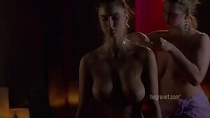 One woman oiling up another woman's body