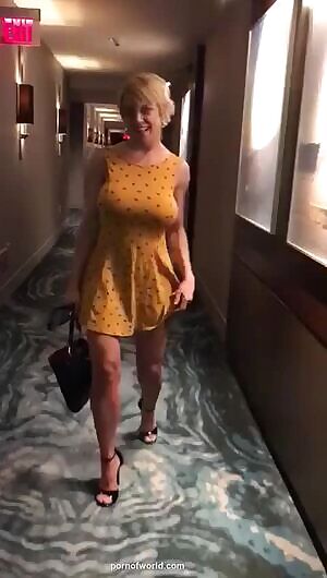 Busty blonde removes dress in hotel hallway