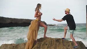 Kate Upton getting knocked over by a wave during photoshoot